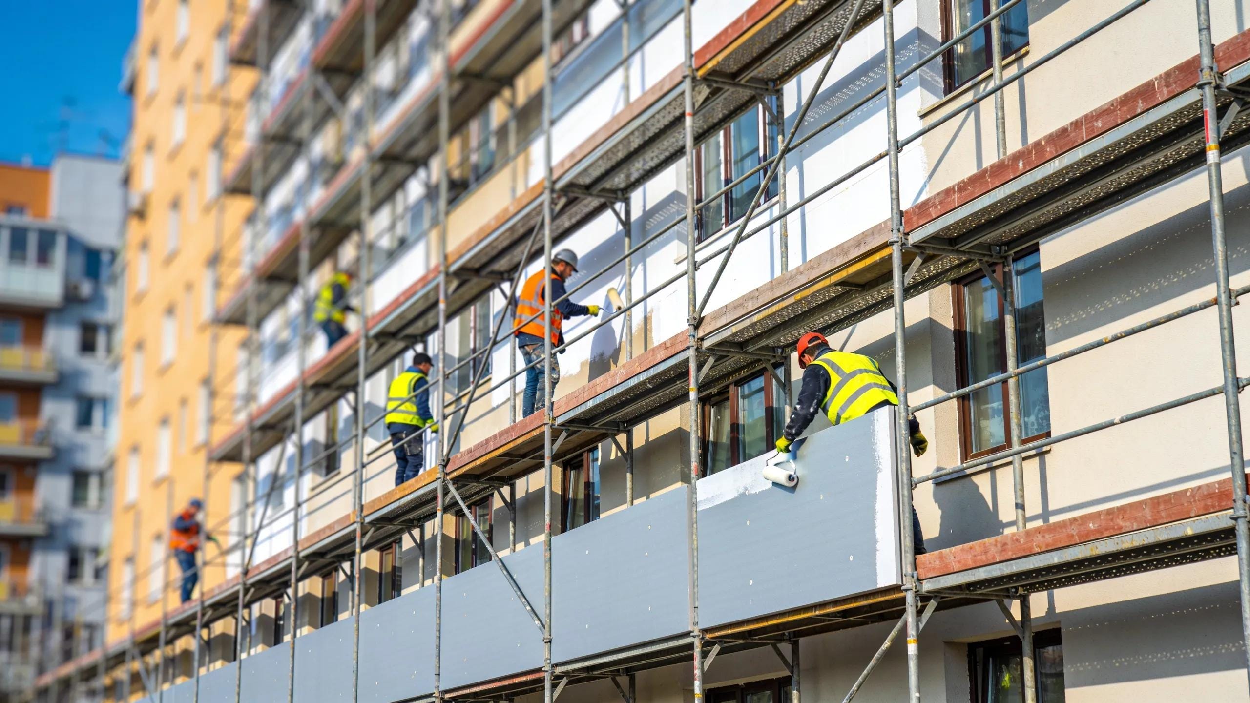 Facade renovation in progress with workers and scaffolding